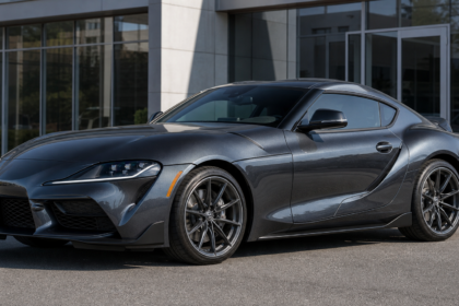 Toyota GR Supra 2.0 in dark metallic gray photographed from the front three-quarter angle outdoors